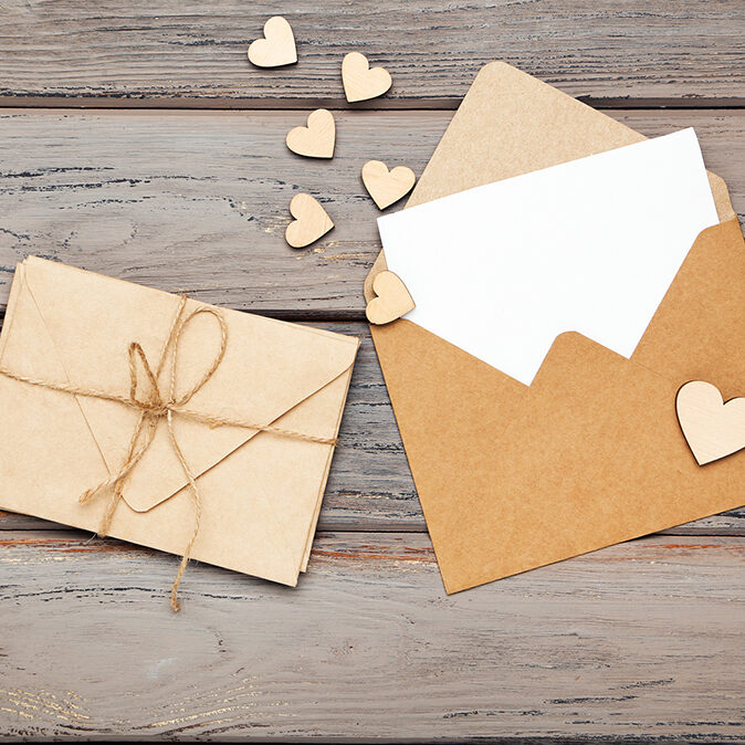Gift Certificates - Paper envelopes with small hearts on wooden table